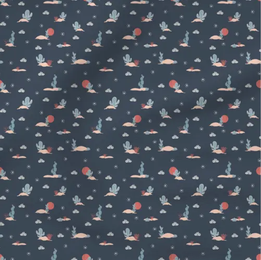 navy blue fabric print featuring cacti and a desert theme